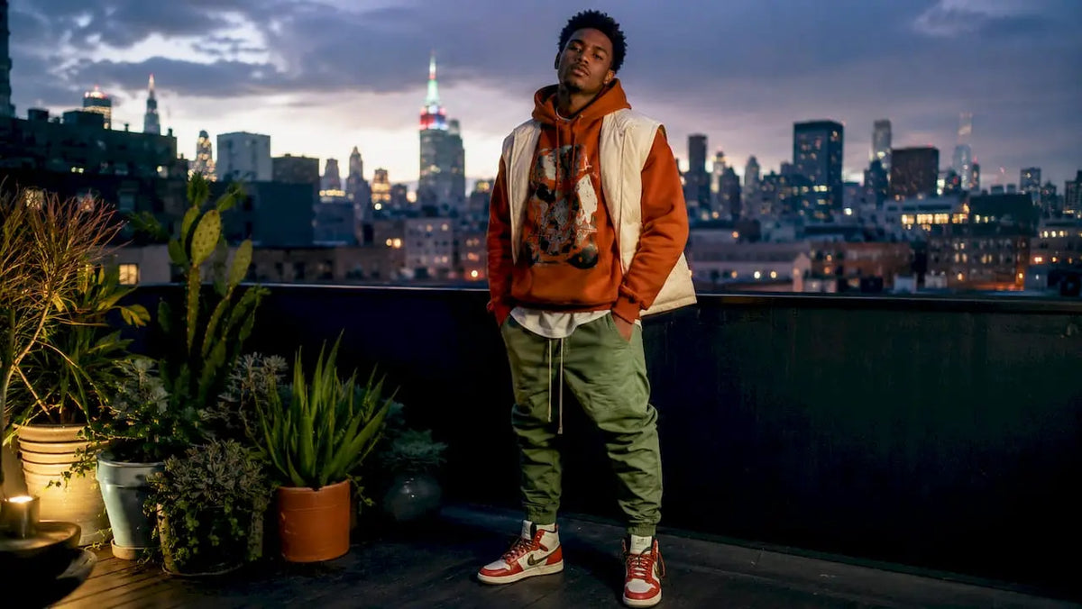 Young man wearing layered streetwear on city street